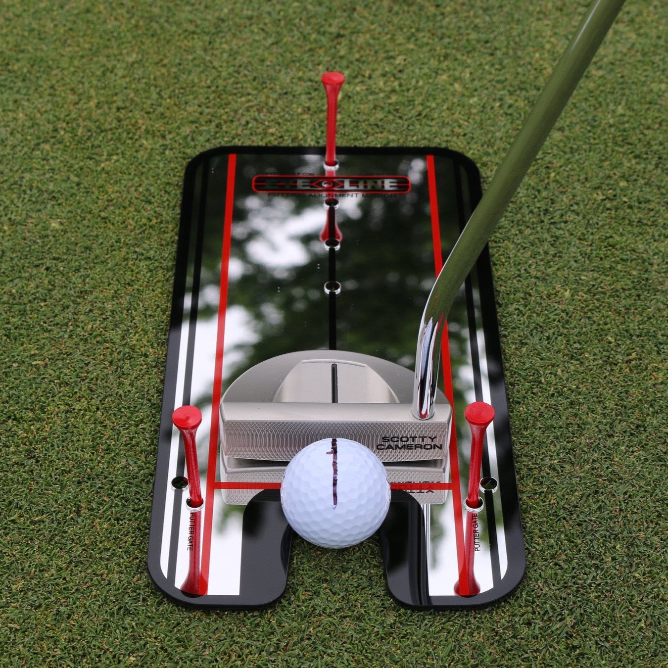 Golf putting alignment mirror with eye-line guides on green